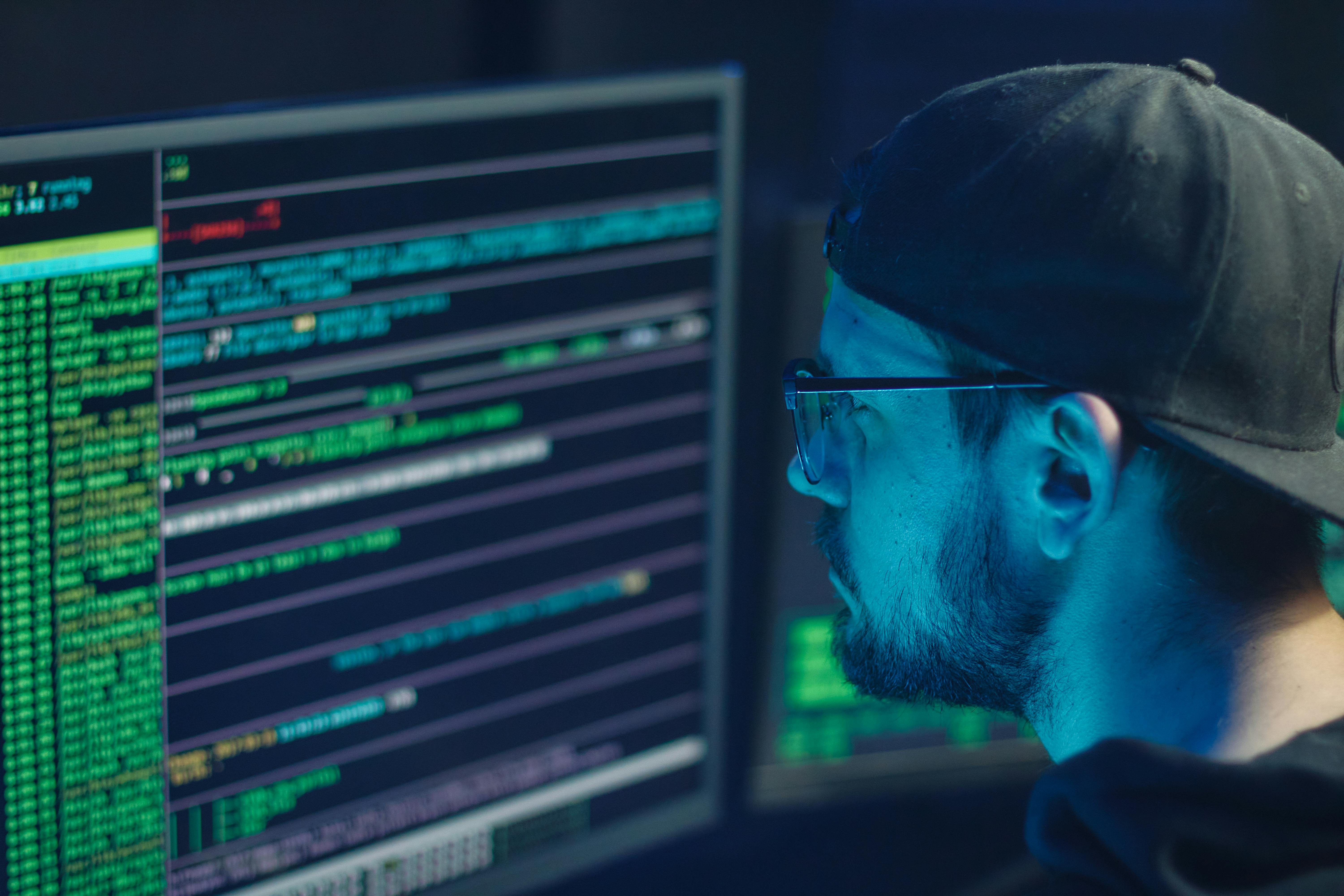 Security analyst monitoring application dashboards across multiple screens.